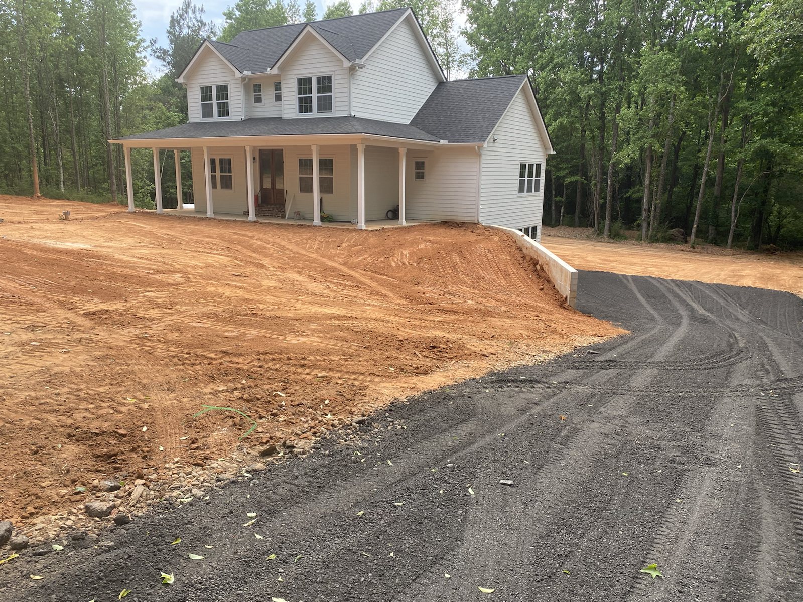 Finished house pad and driveway beside a new home